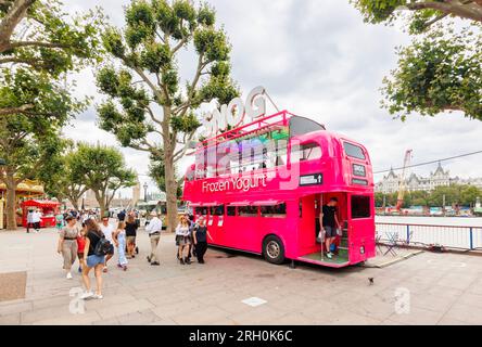 Ein rosafarbener umgebauter Bus, der auf Queen's Walk an der South Bank of the Thames Embankment, London SE1, Eisjoghurt-Snacks verkauft Stockfoto