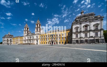 Nationalpalast Mafra, Portugal. Großer barocker und neoklassizistischer königlicher Komplex mit Basilika und Twin-Türmen unter blauem Himmel. UNESCO-Weltkulturerbe. Stockfoto