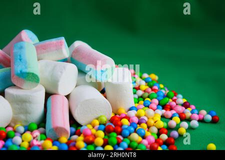 Marshmallows über farbigen Kugeln mit grünem Hintergrund Stockfoto