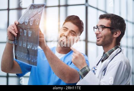 Zwei weiße Ärzte betrachten das mrt-Bild und diskutieren darüber. Schließen. Stockfoto