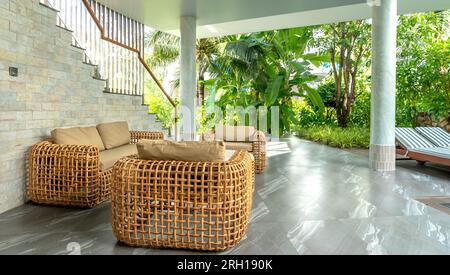 Bambus- und Rattan-Sofabett mit ruhiger Grünfläche Stockfoto