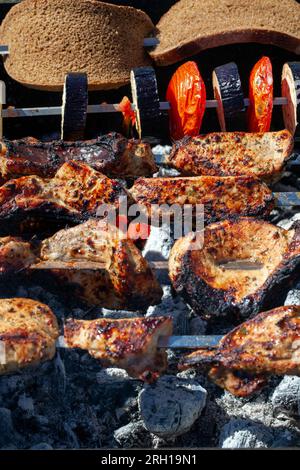 Grillen Sie mit dem Kochen von Fleisch auf dem Feuer, Fleisch in Stücke geschnitten, während Sie auf dem Grill kochen Stockfoto