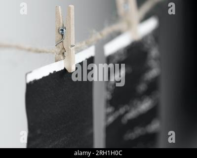 Nahaufnahme von am Seil hängenden Fotorahmen mit Holznadeln. Stockfoto