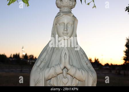 "Göttliche Ruhe, Eine fesselnde Marmorstatue einer Frau im Gebet, die ein tiefes Gefühl von Frieden und spiritueller Betrachtung hervorruft." Stockfoto