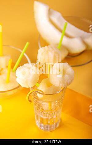 Hausgemachte Melone Orange Obst Sorbet Granita Eis Lollies und Scheiben von frischen reifen Melone Obst über auf gelbem Hintergrund. Draufsicht. Sommer Dessert Stockfoto
