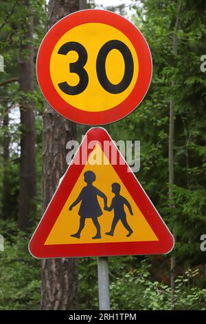 Nahaufnahme von Kindern und Geschwindigkeitsbegrenzung auf dreißig Straßenschilder. Stockfoto