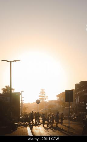 Marina di Ragusa, Sizilien - 27. Juli 2023: Menschen badeten im Licht des Sonnenuntergangs, spazierten in der nebeligen Luftfeuchtigkeit eines heißen Sommertages Stockfoto