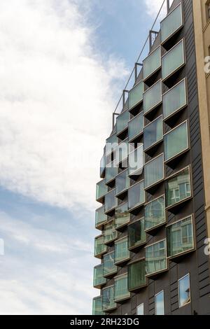 Blick nach oben auf die rotierte diagonale Glasfassade mit Fenstern der modernen Fassade in Barcelona Stockfoto