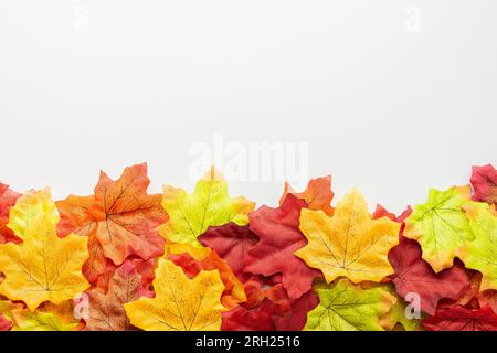 Herbstzusammensetzung. Rahmen aus Herbstblättern auf weißem Hintergrund. Blätter unten. Flach verlegt. Speicherplatz kopieren. Draufsicht Stockfoto