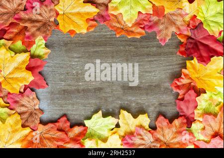 Herbstzusammensetzung. Rahmen aus Herbstblättern auf Holzhintergrund. Rechteckiger Rahmen. Flach verlegt. Speicherplatz kopieren. Draufsicht Stockfoto
