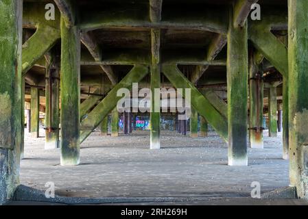 Unter dem Sandown Pier, symmetrisches Bild, das die Stützen und die Verwitterung zeigt. August 2023 Stockfoto