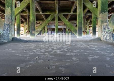 Unter dem Sandown Pier, symmetrisches Bild, das die Stützen und die Verwitterung zeigt. August 2023 Stockfoto