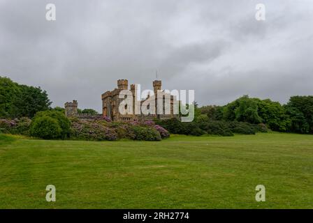 Lews Castle liegt über der Stadt Stornoway in den äußeren Hebriden und befindet sich an einem bedeckten Tag im Juni auf einer grünen Inline unter blühenden Azaleen. Stockfoto