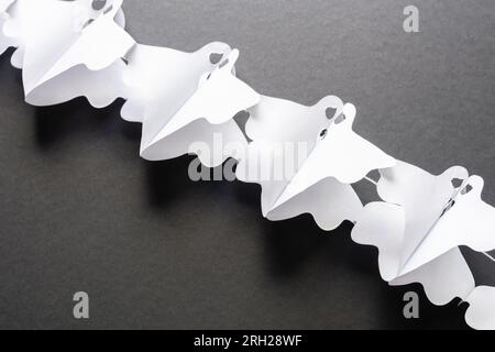 Trick-or-Treat-Konzept. Weihnachtskomposition mit halloween Girlande Dekorationen Geister isoliert auf schwarzem Hintergrund. Vorbereitung auf die Halloween-Party. Stockfoto