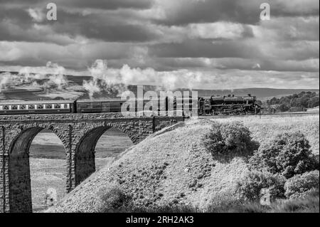 Das Bild zeigt die Dampfeisenbahn der British Railways, Black 5 MT, 4-6-0, 44932, die über das ikonische Viadukt Ribblehead in den North Yorkshire Dales fährt Stockfoto