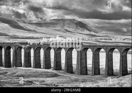 Das Bild zeigt die Dampfeisenbahn der British Railways, Black 5 MT, 4-6-0, 44932, die über das ikonische Viadukt Ribblehead in den North Yorkshire Dales fährt Stockfoto