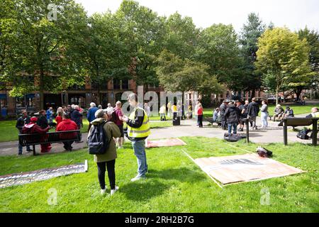 Manchester, Großbritannien. 12. Aug. 2023. Sackville Gardens. Am 12. August 2023 tauchte eine Menschenmenge von etwa 80 Menschen auf, um das Massaker von Peterloo vom 16. August 1819 in Manchester zu begehen. Die Organisatoren beschuldigten eine rivalisierende Veranstaltung "Peterloo March for Democracy", die für den 19. August 2023 organisiert wird, sowie andere Proteste und Veranstaltungen wie den Karneval der Karibik von Manchester, einen Protest der Trans Right und einen Protest des iranischen Proregime gegen den Wandel auf dem St. Peters-Platz in Manchester. Die kleine Menge marschierte zum Peterloo-Massaker-Denkmal im Zentrum von Manchester. An der Sitzung nahmen auch Klimaschutzfragen Teil Stockfoto