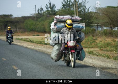 Ein männlicher Boda Boda Motorradfahrer, der Säcke Holzkohle auf seinem Motorrad trägt, Nakuru, Kenia, Ostafrika Stockfoto