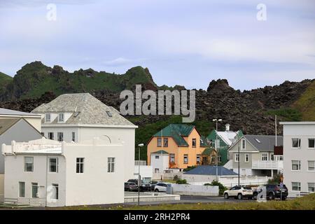 Blick auf das Dorf Heimaey auf Heimaey Island, mit dem Lavastrom von Eldfell Volcano-Vestmannaeyjar-Insel im Hintergrund Stockfoto