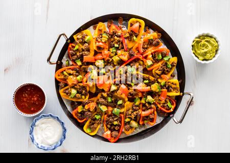 Eine Platte mit Mini-Paprika-Nachos, frisch aus dem Ofen, mit Dips. Stockfoto