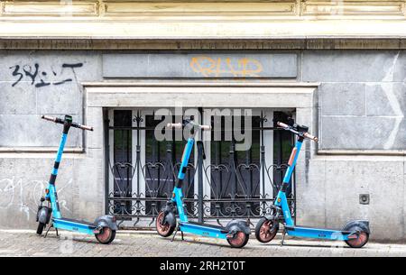 Drei selbstfahrende Elektroroller von DOTT, die auf dem Bürgersteig in der Innenstadt in Brüssel, Belgien, geparkt sind. Stockfoto