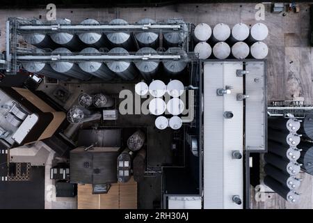 Luftaufnahme direkt über großen Lagertanks in einer Reihe für die Lebensmittelproduktion oder die Lagerung von Chemikalien in einem Industriewerk oder einer Fabrik Stockfoto