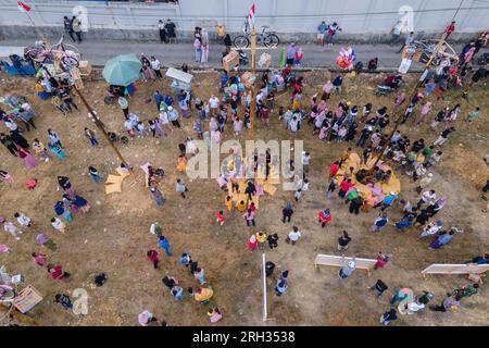 Kendari, Indonesien. 13. Aug. 2023. (ANMERKUNG DER REDAKTION: Bild mit einer Drohne aufgenommen)aus der Vogelperspektive begeisterter Bewohner, die das Rennen beobachten. Der Areka-Kletterwettbewerb wurde von der Vereinigung der Bewohner des Lahundape-Unterbezirks West kendari durchgeführt (13/8/2023). Dies geschah im Gedenken an Indonesiens 78. Jahr der Unabhängigkeit am 17. August. (Foto: Andry Denisah/SOPA Images/Sipa USA) Guthaben: SIPA USA/Alamy Live News Stockfoto