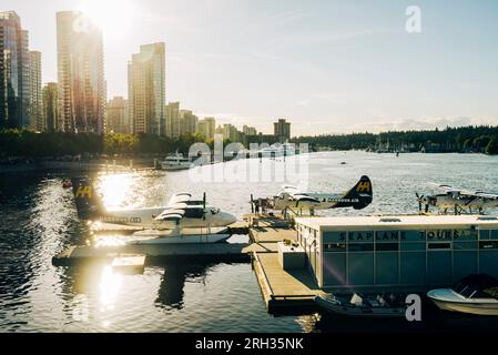 Am Anlegesteg verlegen Wasserflugzeuge mit den Wolkenkratzern von Vancouver im Hintergrund in Kanada Stockfoto