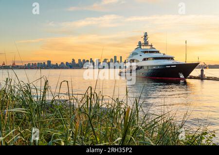 Eine große Luxusyacht liegt im Hafen von Vancouver vor Anker mit Blick auf die Stadt im Hintergrund in Vancouver, Kanada Stockfoto