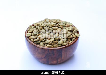 Grüne Kaffeebohnen in einer Holzschale auf weißem Hintergrund Stockfoto