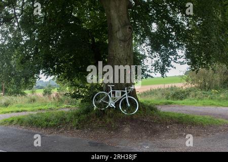 White Memorial Bicycle UK. Ghostcycle auch bekannt als Ghost Bike. Radfahrer auf dem Land, der auf seinem Tretrad getötet wurde, radelte auf einer Landstraße nach Hause. Die Fahrbahnmarkierungen waren kaum sichtbar. Sarum Road und Woodman Lane, bei Sparsholt. Hampshire UK 2023 2020s England. HOMER SYKES Stockfoto