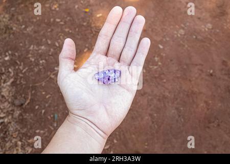 Nahaufnahme eines sauberen, weißen Hand haltenden Amethyst-Stücks Stockfoto