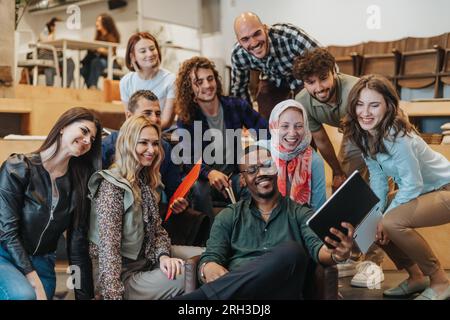 Vielfältige Gruppe von Kollegen, die Selfie im Büro machen. Andere alte, glückliche Geschäftskollegen machen ein Selfie Stockfoto