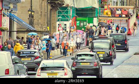 Edinburgh, Schottland, Großbritannien. 13h. August 2023. UK Weather: Der lange Weg von den Wiesen zum Zentrum. Es war warm und nass, als die Touristen die Straßen der Stadt inmitten der Straßenränder mit ihren Läden befallen haben. Credit Gerard Ferry/Alamy Live News Stockfoto