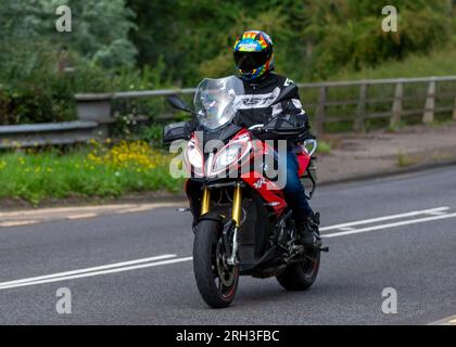 Milton Keynes, Großbritannien - Aug 13. 2023:2016 roter BMW S 1000 XR Motorrad fährt auf einer englischen Landstraße. Stockfoto