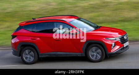 Milton Keynes, Großbritannien - Aug 10. 2023: 2022 Red Hundai Tucson Hybrid-Elektroauto, das auf einer englischen Landstraße fährt. Stockfoto