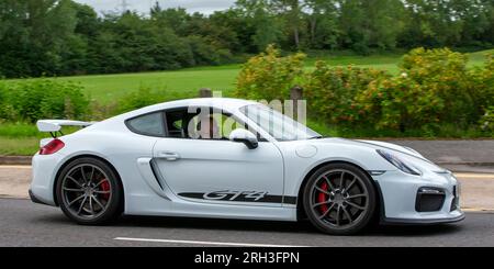 Milton Keynes, Großbritannien - Aug 10. 2023: 2016 weißer Porsche Cayman GT4 Auto, das auf einer englischen Landstraße fährt. Stockfoto