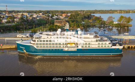 Das Expeditionsschiff SH MINERVA liegt im Hafen von Fray Bentos. Blick aus der Vogelperspektive während des Abendlichts. Stockfoto