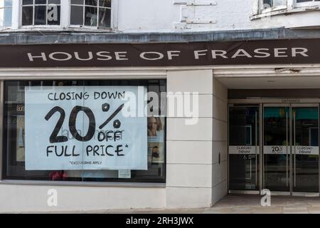 Das Kaufhaus House of Fraser in Guildford, Surrey, England, wird am 30. 2023. September geschlossen. Auf dem Foto vom 13. 2023. August wird auf großen Plakaten in den Schaufenstern des Ladengeschäfts mit einem Rabatt von 20 % beim Abschluss des Verkaufsangebots geworben. Stockfoto