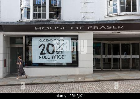 Das Kaufhaus House of Fraser in Guildford, Surrey, England, wird am 30. 2023. September geschlossen. Auf dem Foto vom 13. 2023. August wird auf großen Plakaten in den Schaufenstern des Ladengeschäfts mit einem Rabatt von 20 % beim Abschluss des Verkaufsangebots geworben. Stockfoto