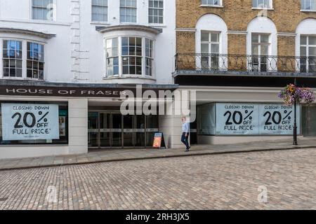 Das Kaufhaus House of Fraser in Guildford, Surrey, England, wird am 30. 2023. September geschlossen. Auf dem Foto vom 13. 2023. August wird auf großen Plakaten in den Schaufenstern des Ladengeschäfts mit einem Rabatt von 20 % beim Abschluss des Verkaufsangebots geworben. Stockfoto