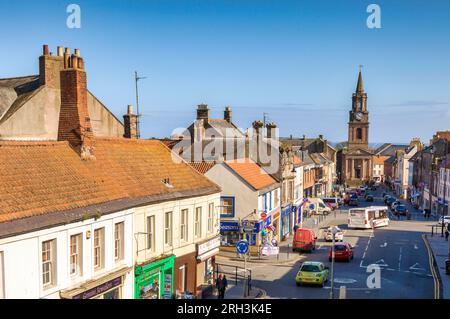 14. April 2016: Berwick-on-Tweed, Northumberland, Großbritannien - Marygate, geschäftig mit Einkäufern, Verkehr und einem Bus, und das Rathaus mit seinem historischen Uhrenturm. Stockfoto