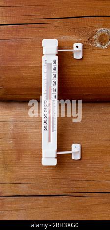 Thermometer an der Wand eines Holzhauses. Wetterthermometer in Grad celsius. Stockfoto