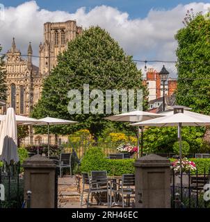 Wells, Somerset, England, Großbritannien. 21. Juni 2023 Speisesaal im Hotelgarten mit Gästen, die einen Drink mit Blick auf die Kathedrale von Wells genießen, Stockfoto