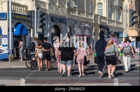 Weston Super Mare, Somerset, England, Großbritannien. 25. Juni 2023 Urlauber überqueren die Straße am Strand in Richtung Stadtzentrum, Weston. Stockfoto