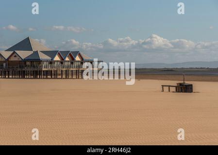 Weston Super Mare, Somerset, England, Großbritannien. 25. Juni 2023. Der große leere Strand im Weston Super Mare, Somerset, England, mit modernem Café-Restaurant Stockfoto