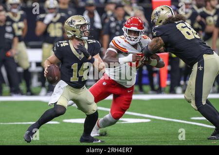 New Orleans, USA. 13. August 2023: Der Quarterback der New Orleans Saints Jake Haener (14) wird vom Kansas City Defensivlineman Felix Anudike-Uzomah (97) während der NFL-Vorsaison zwischen den New Orleans Saints und den Kansas City Chiefs im Caesars Superdome in New Orleans, LA, aus der Tasche gedrängt. Jonathan Mailhes/CSM (Kreditbild: © Jonathan Mailhes/Cal Sport Media) Kredit: CAL Sport Media/Alamy Live News Stockfoto