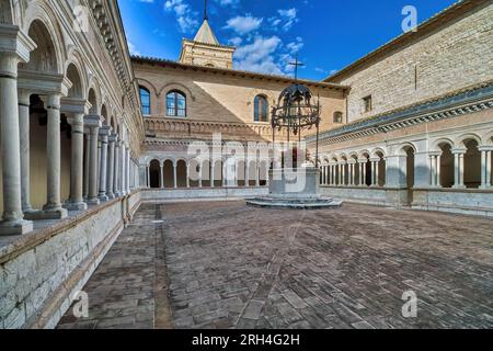 Foligno, Umbrien, Italien. Abbey of Santa Croce (1070 in Sassovivo). Romanischer Kreuzgang (1229) mit viereckigem Grundriss und einem Brunnen in der Mitte. Stockfoto