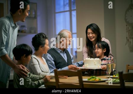 Eine asiatische Familie aus drei Generationen zu Hause, um den Hochzeitstag des Seniorenpaares zu feiern Stockfoto