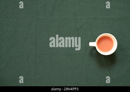 Tasse Pink Tee auf grünem Stofftisch. Draufsicht, Kopierbereich Stockfoto